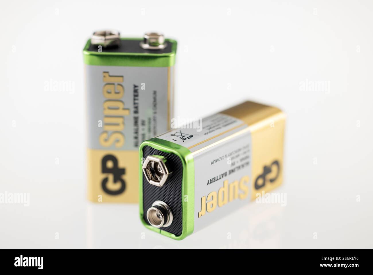 Two new GP 9 volt block batteries plus and minus pole blurred white