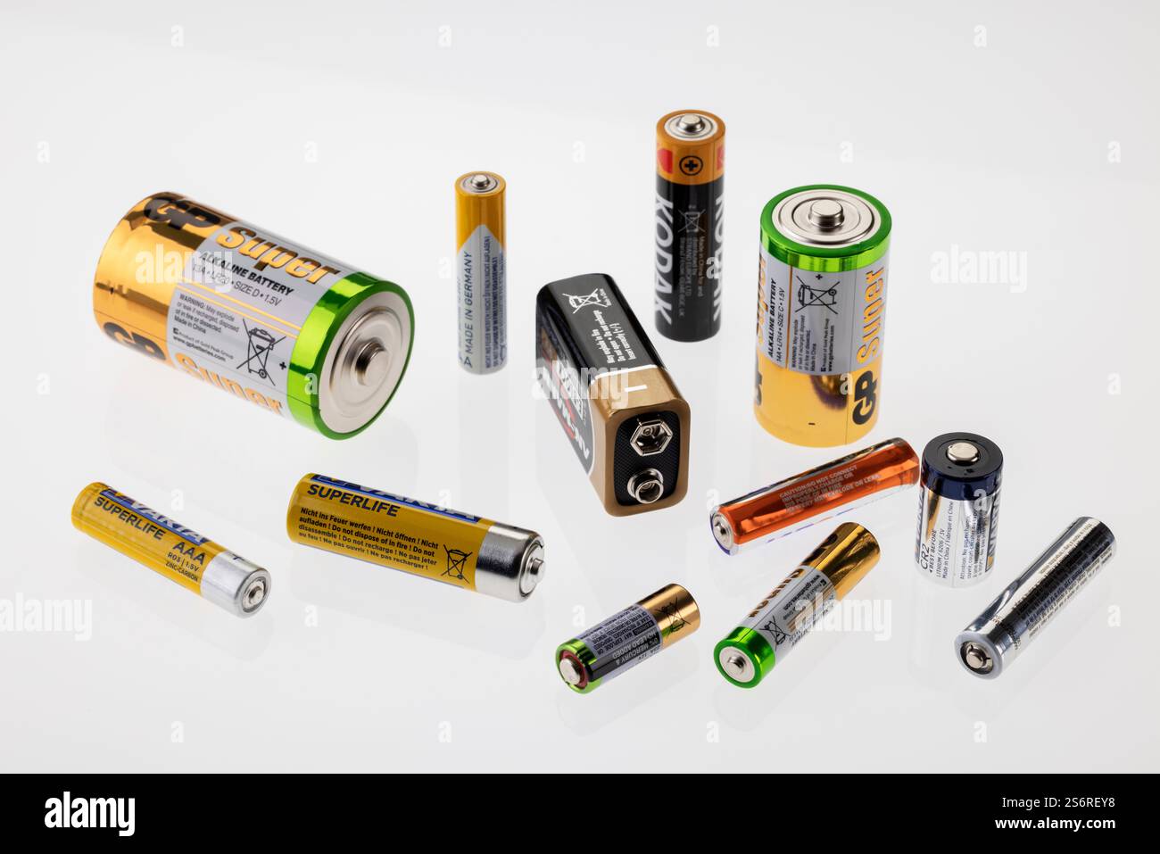 New batteries from different manufacturers, different sizes, white background, Stock Photo