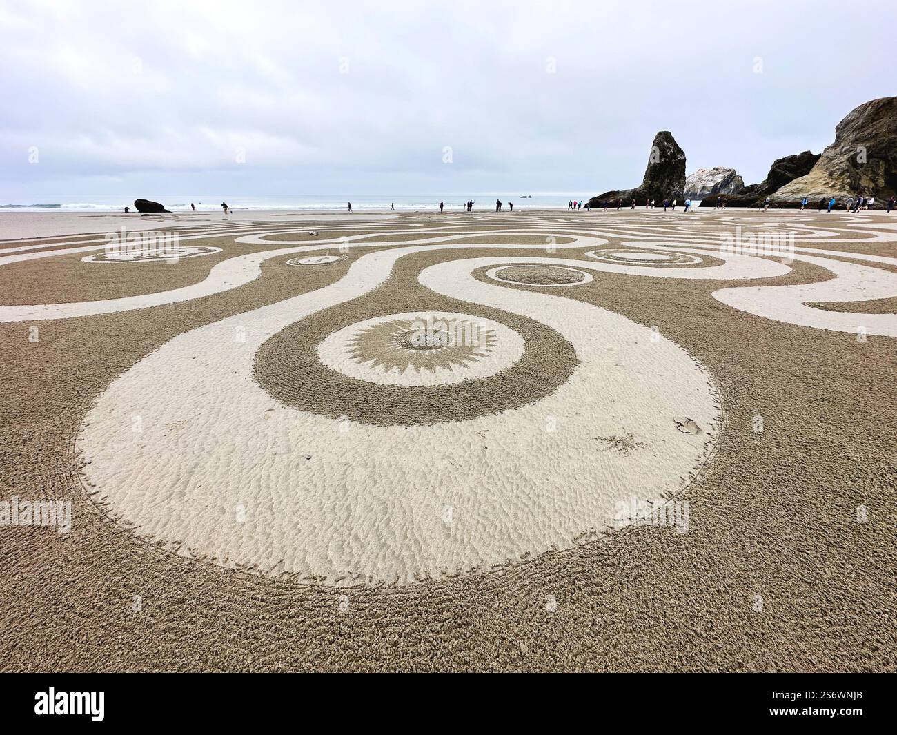 People walking a Circles in the Sand labyrinth at Face Rock Beach in Bandon, Oregon. - Smartphone Captured Stock Image