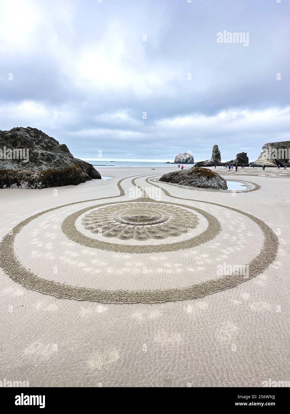 People walking a Circles in the Sand labyrinth at Face Rock Beach in Bandon, Oregon. - Smartphone Captured Stock Image