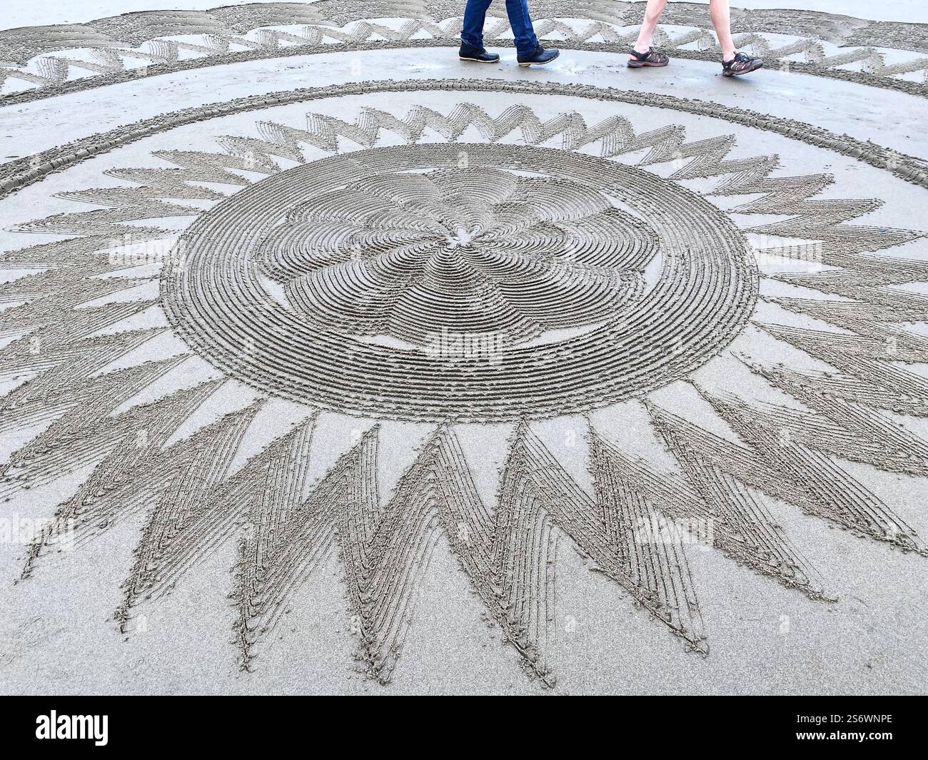 People walking the Circles in the Sand labyrinth at Face Rock Beach in Bandon, Oregon. - Smartphone Captured Stock Image