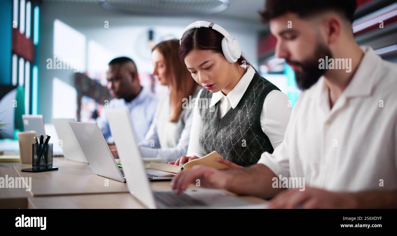 University Student At Library With Laptop Doing Assignment And Preparing For Exam Stock Photo