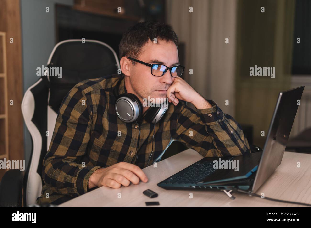 portrait of his he nice attractive focused professional guy coding programming supporting website remotely at modern work place station. the young man Stock Photo