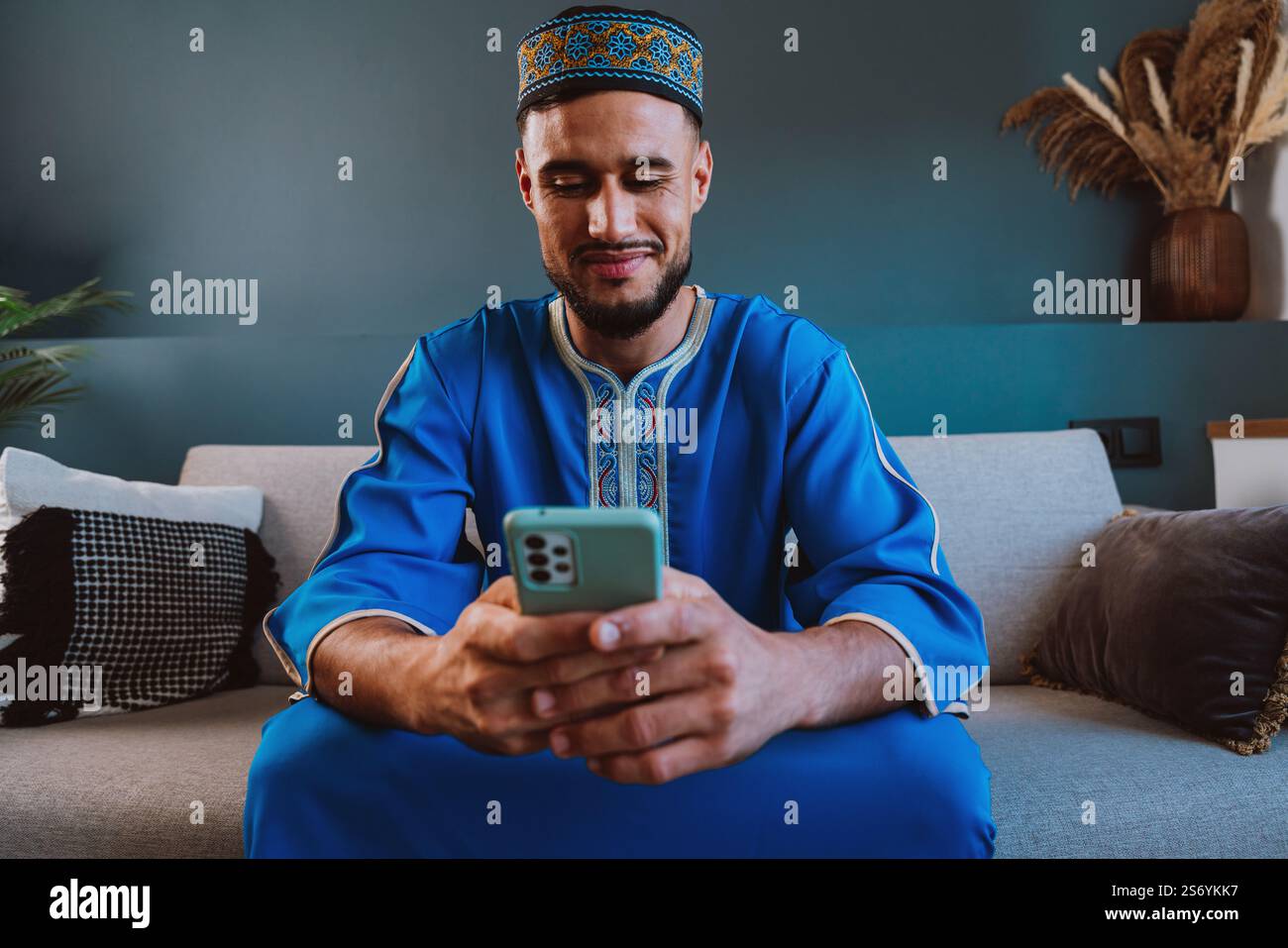 Moroccan guy with traditional outfit using smartphone. Stock Photo