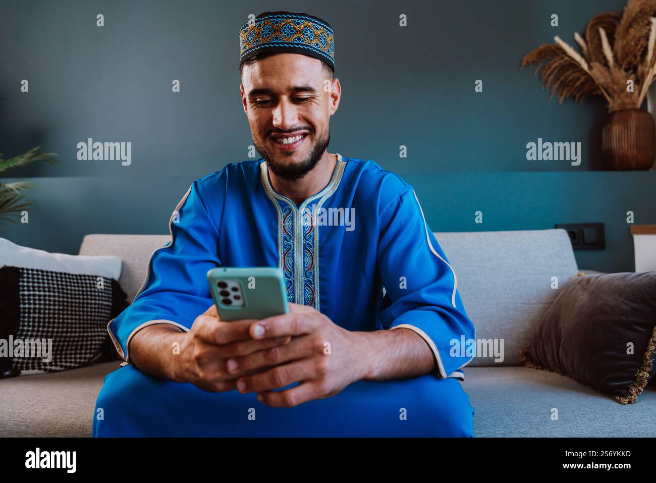 Moroccan guy with traditional outfit using smartphone. Stock Photo