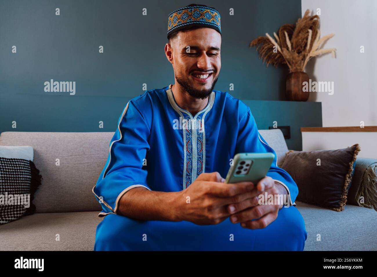 Moroccan guy with traditional outfit using smartphone. Stock Photo