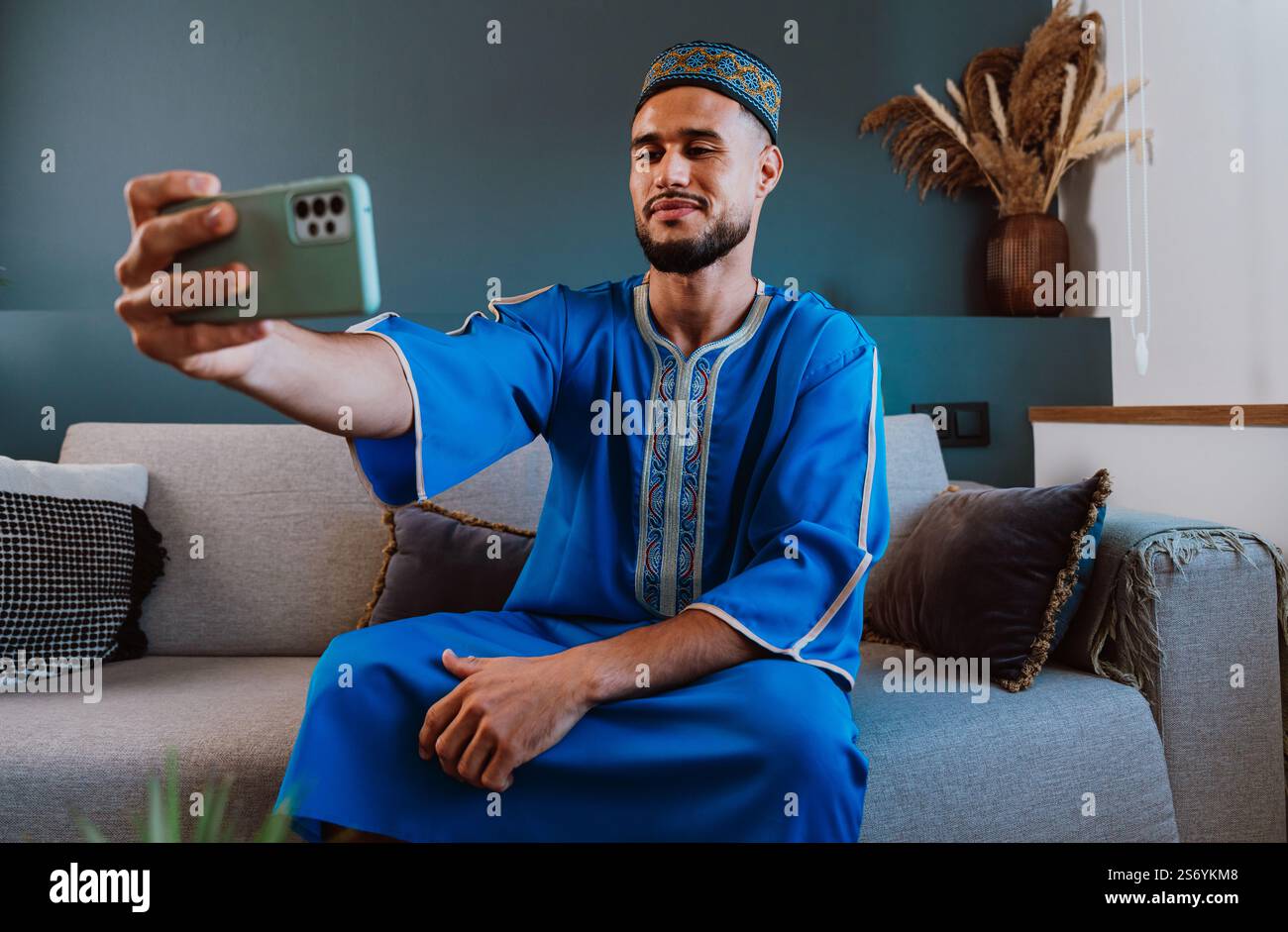 Moroccan guy with traditional outfit using smartphone and taking selfies. Stock Photo
