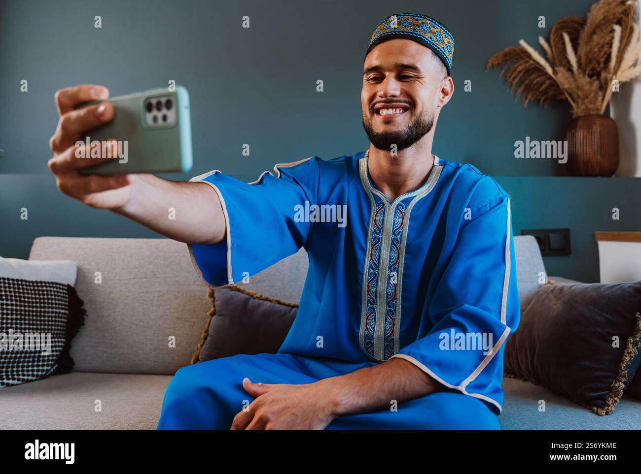 Moroccan guy with traditional outfit using smartphone and taking selfies. Stock Photo
