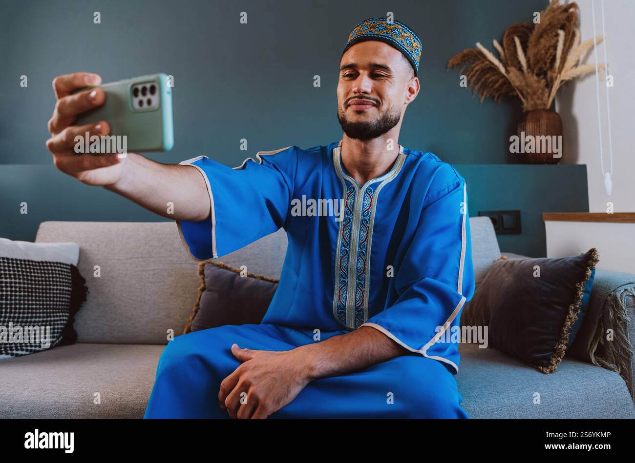 Moroccan guy with traditional outfit using smartphone and taking selfies. Stock Photo