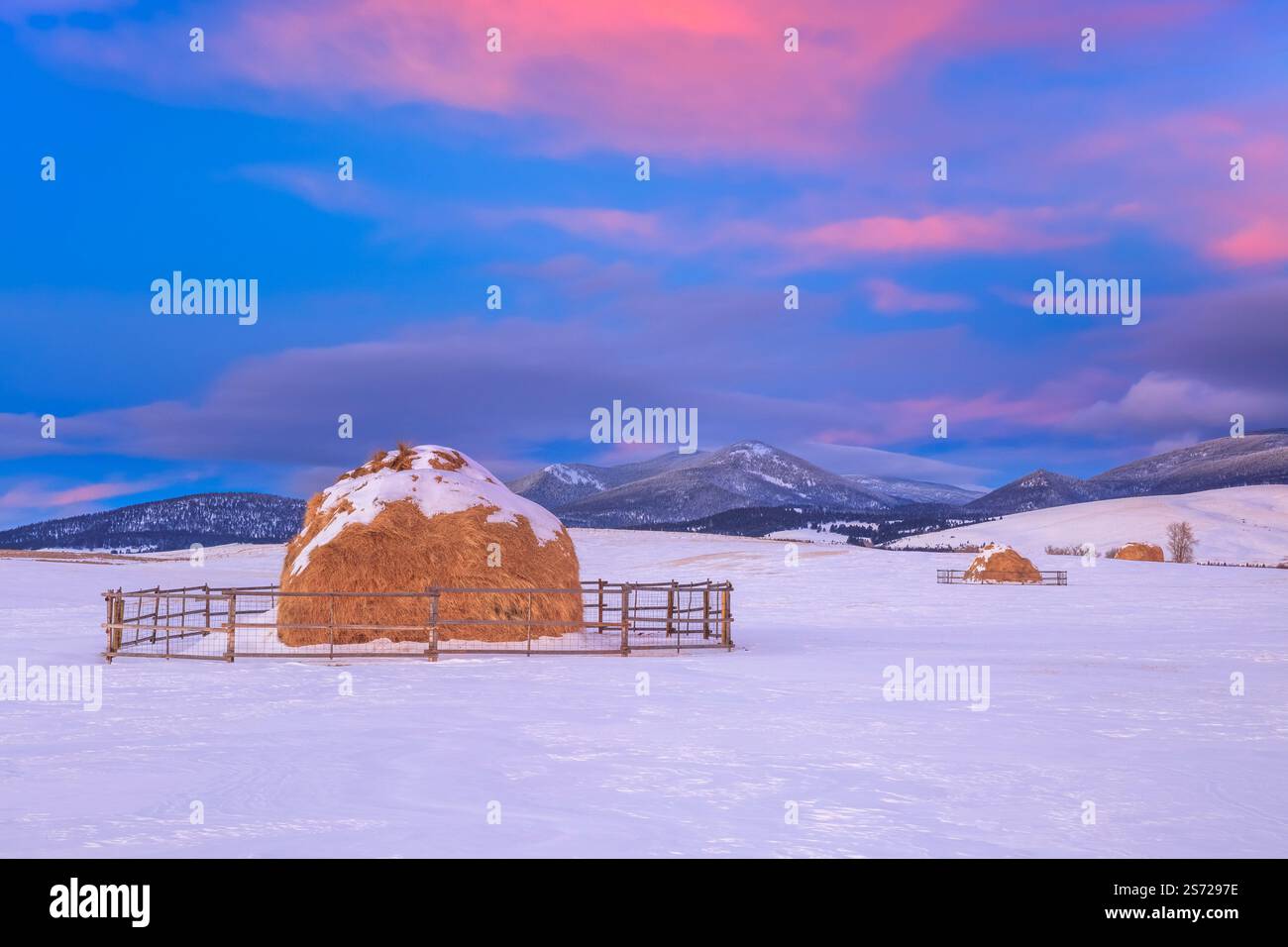 haystacks in winter below black mountain along the continental divide near avon, montana Stock Photo