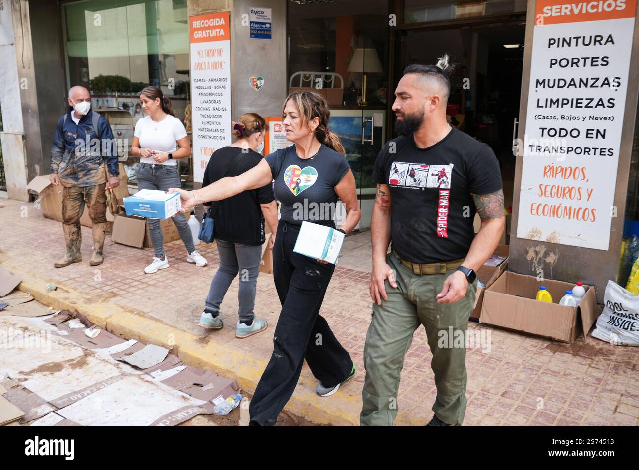 Residents giving surgical masks for free to people walking in the streets to prevent breathing of dangerous inhalations.Alfafar,Spain Stock Photo