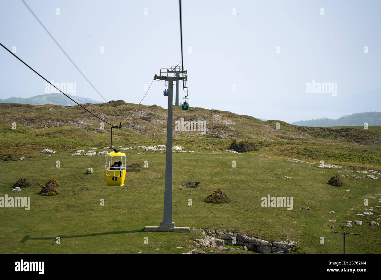 a passenger cable car gondola cabin travelling between pylons, opened ...