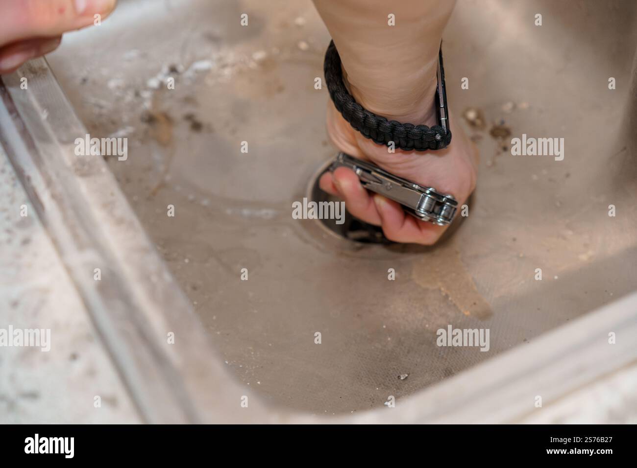 Cleaning a Clogged Kitchen Sink with Tools. Stock Photo