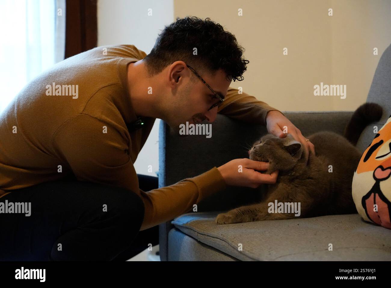 Florence, Italy. 17th Jan, 2025. Giacomo Bechini plays with his cat at home in Florence, Italy, Jan. 17, 2025. TO GO WITH 'Feature: Italian man embarks on first Chinese Spring Festival journey' Credit: Ren Yaoting/Xinhua/Alamy Live News Stock Photo