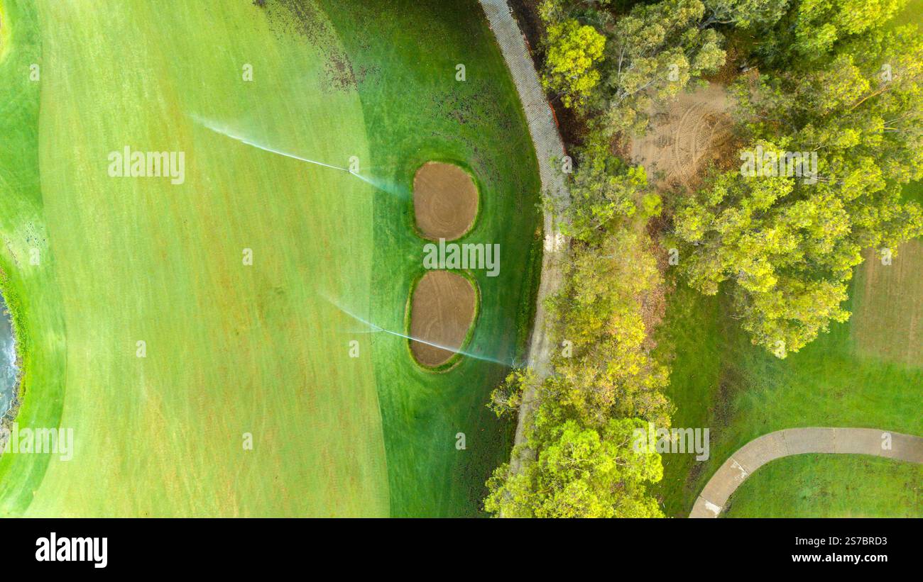 Aerial view of a lush green golf course with sand traps and trees Stock ...