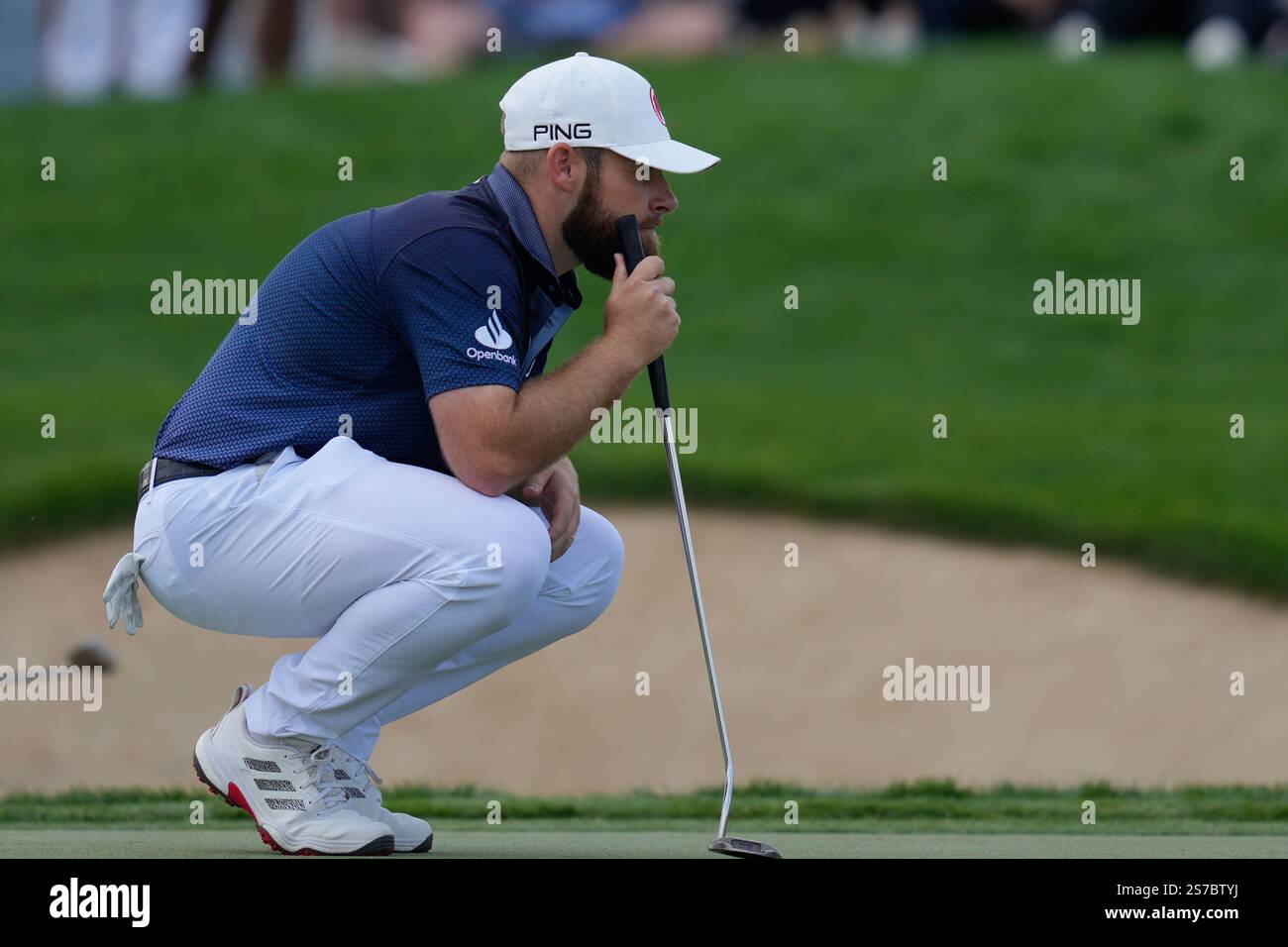 Tyrell Hatton of England lines up a putt on the 18th green during the