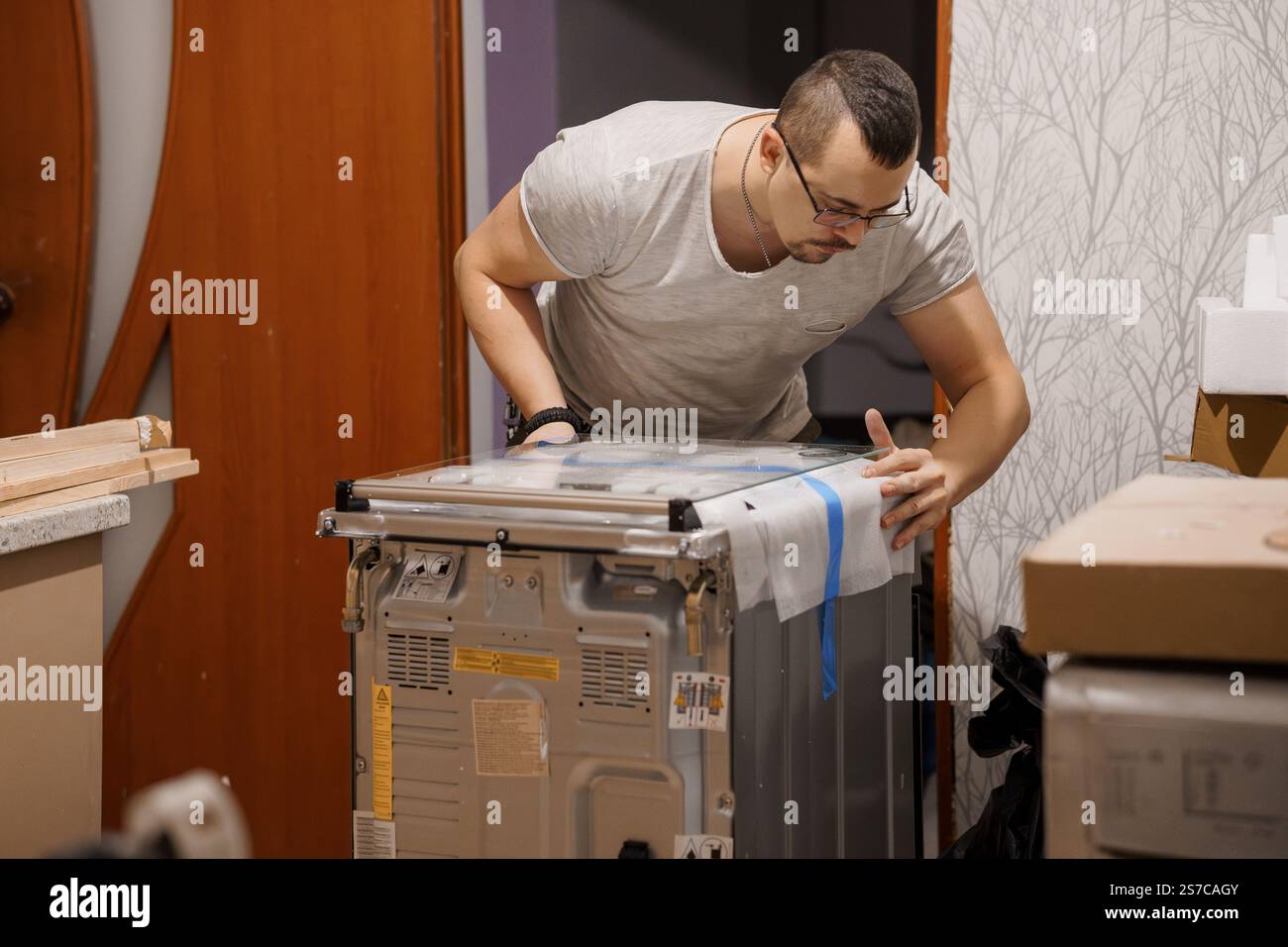 Man installing a dishwasher in a modern kitchen setting stock photo alamy