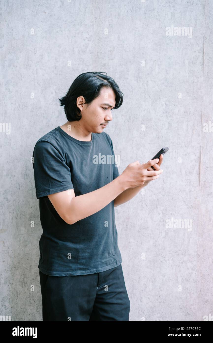 Man texting on his phone, seen from a side perspective. Stock Photo