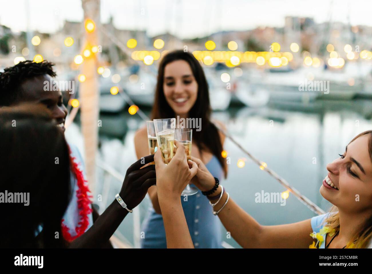 Happy multiracial young people cheering with champagne on a boat party ...