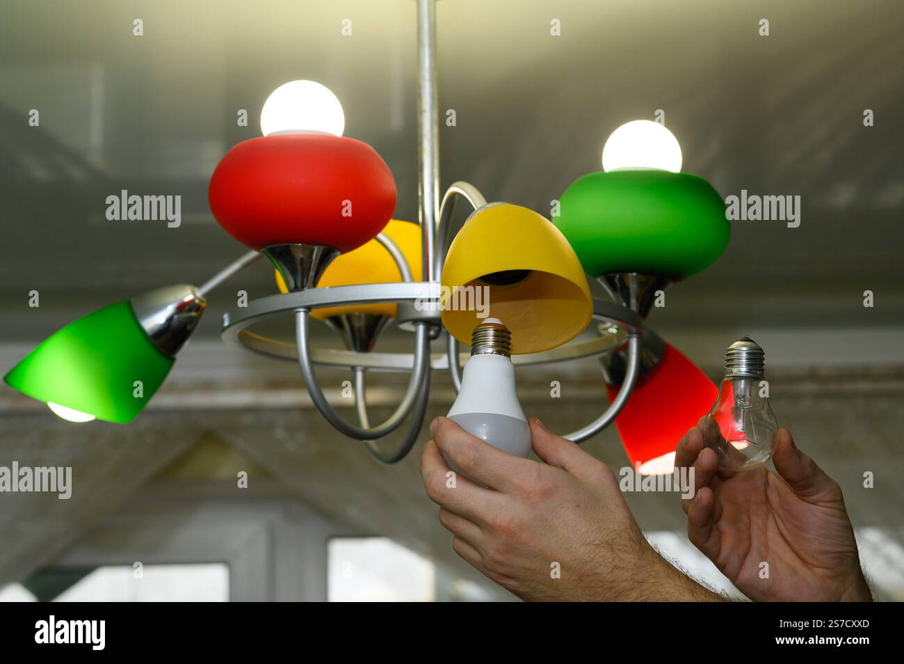 the concept of replacing an incandescent lamp with an LED one. Stock Photo