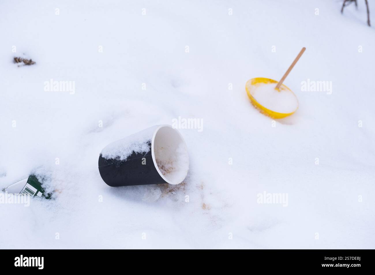 Disposable plastic cup with straw lying on snow Stock Photo