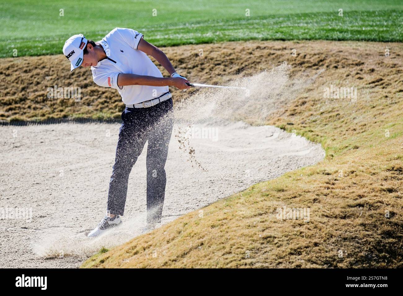 Ryo Hisatsune hits from a bunker toward the 10th green during the final