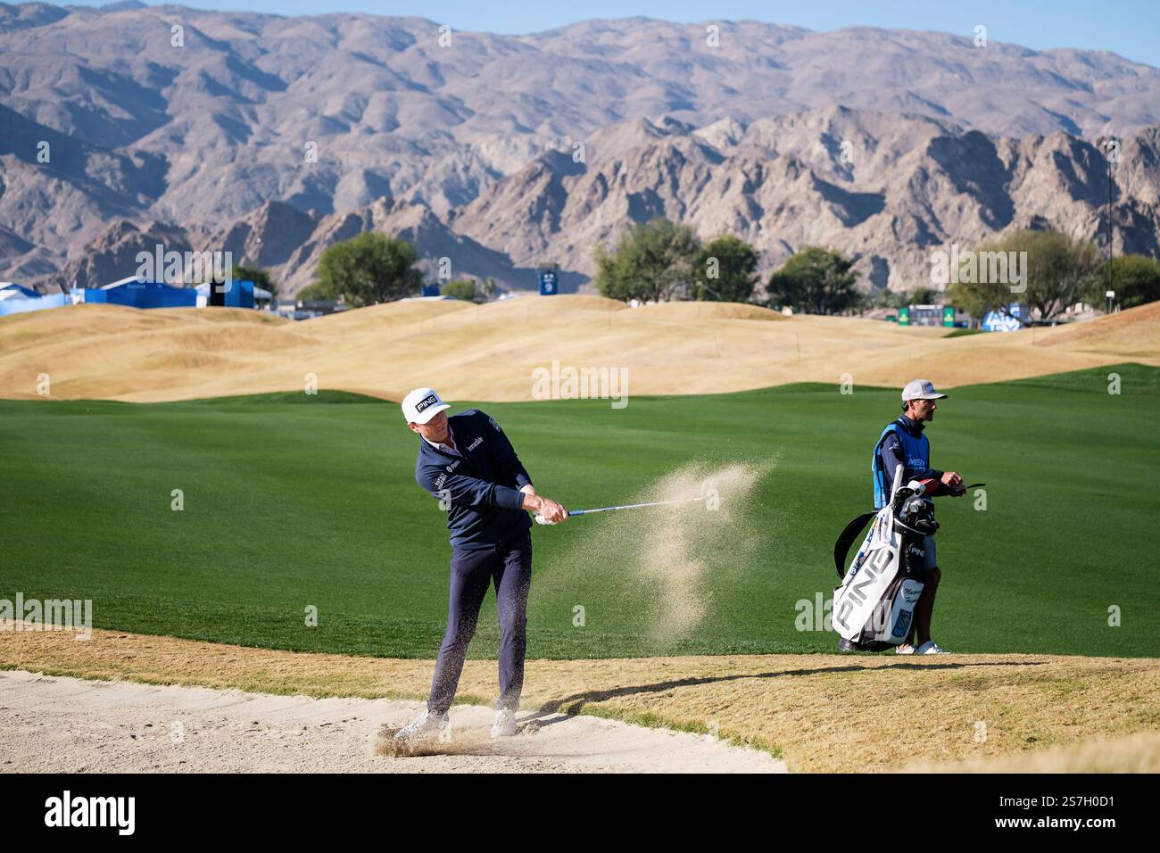 Mackenzie Hughes hits from a bunker toward the first fairway at the
