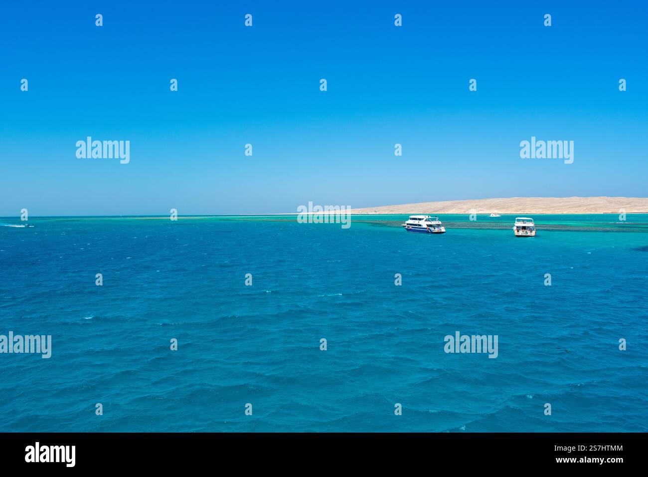 21.01.24 Hurghada, Egypt: Cristal Clear turquoise water of Red Sea at Orange Bay in Giftun Island. Luxury Yachts near Beach at Hurghada, Egypt. Stock Photo