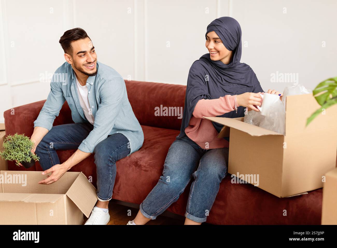 Packing Hijab Happy man and woman in hijab packing or unpacking boxes Stock Photo - Alamy
