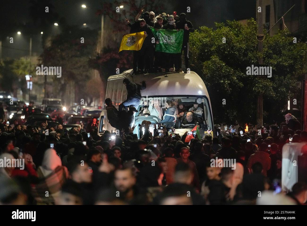 A crowd gathers around a bus carrying released Palestinian prisoners as ...