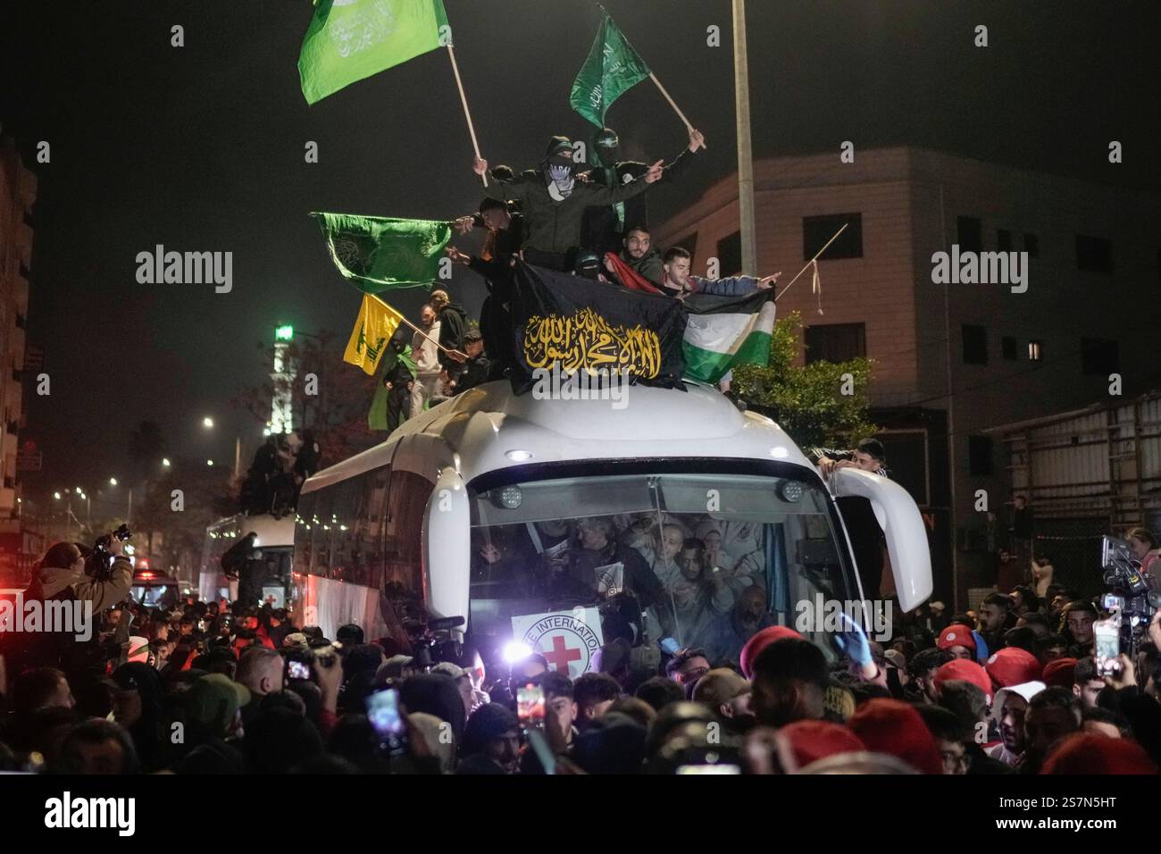 A crowd gathers around a bus carrying released Palestinian prisoners as ...