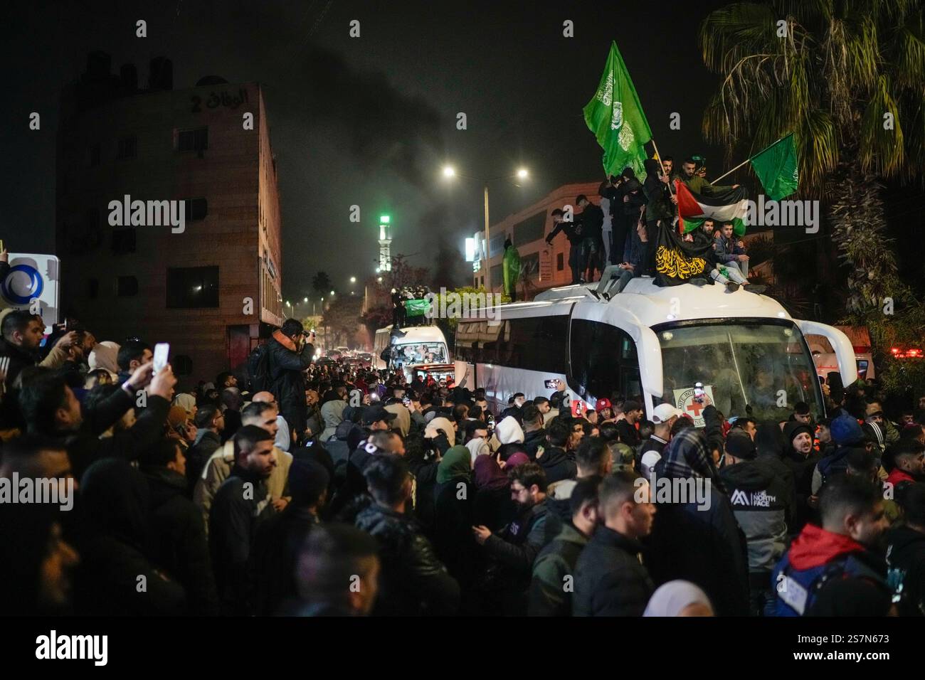 A crowd gathers around buses carrying released Palestinian prisoners as ...