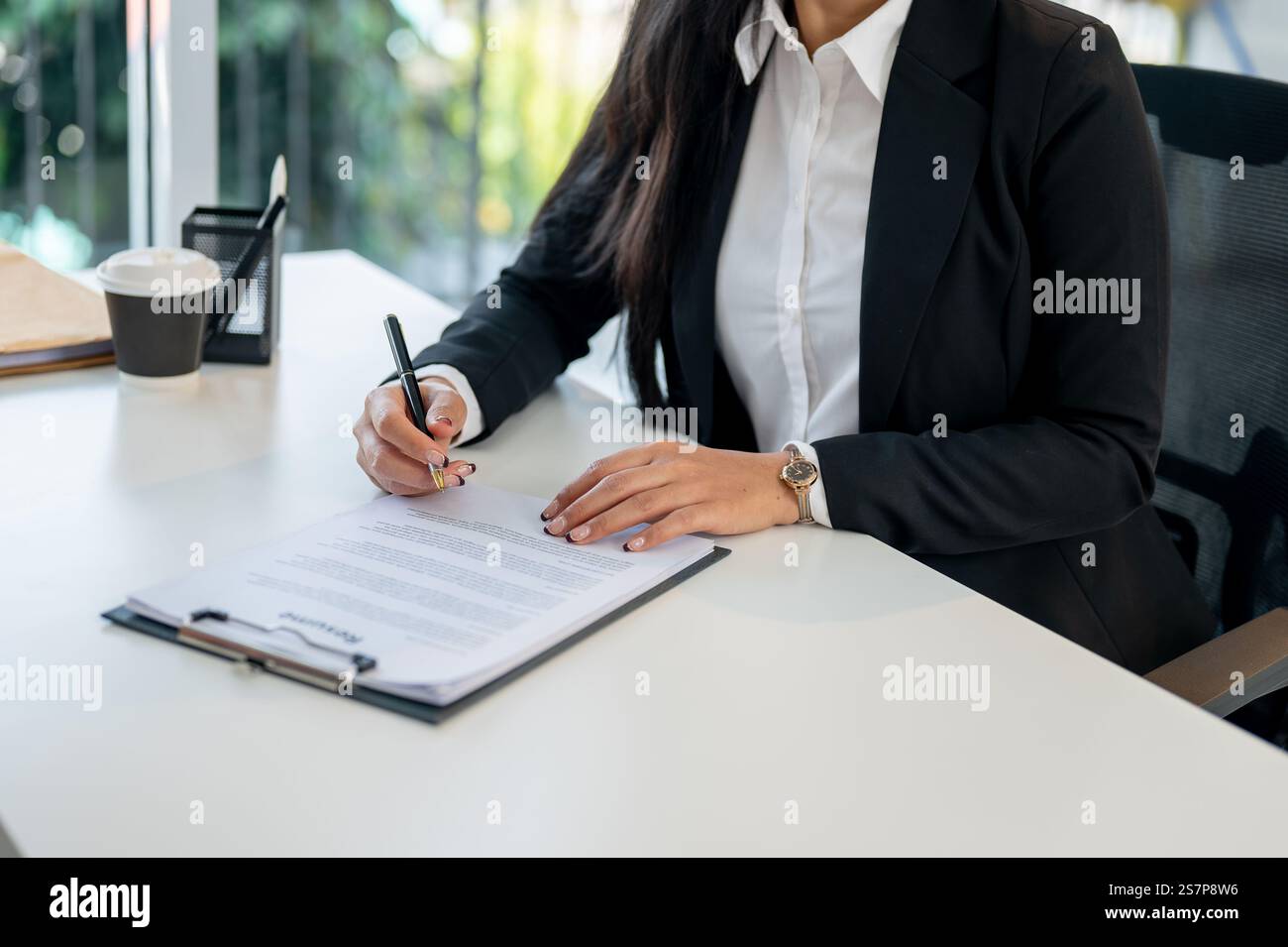 A close-up of a female candidate signing a job contract after the ...