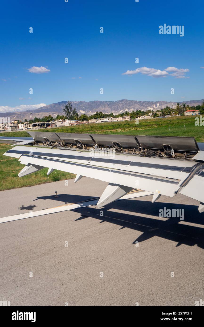 Close-up of an airplane wing with spoilers deployed, showcasing the intricate mechanics in action during landing. Stock Photo