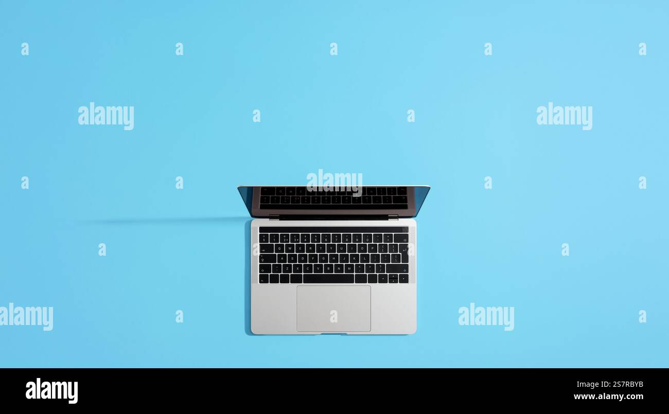 Open laptop computer with blank screen on vibrant blue background ...