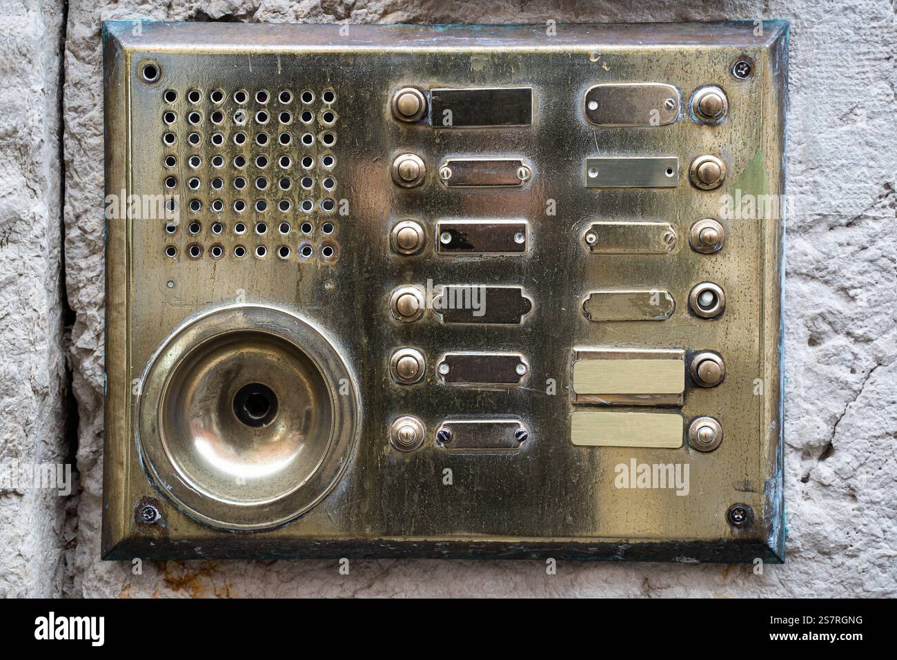 A detailed view of a vintage brass intercom panel featuring multiple ...
