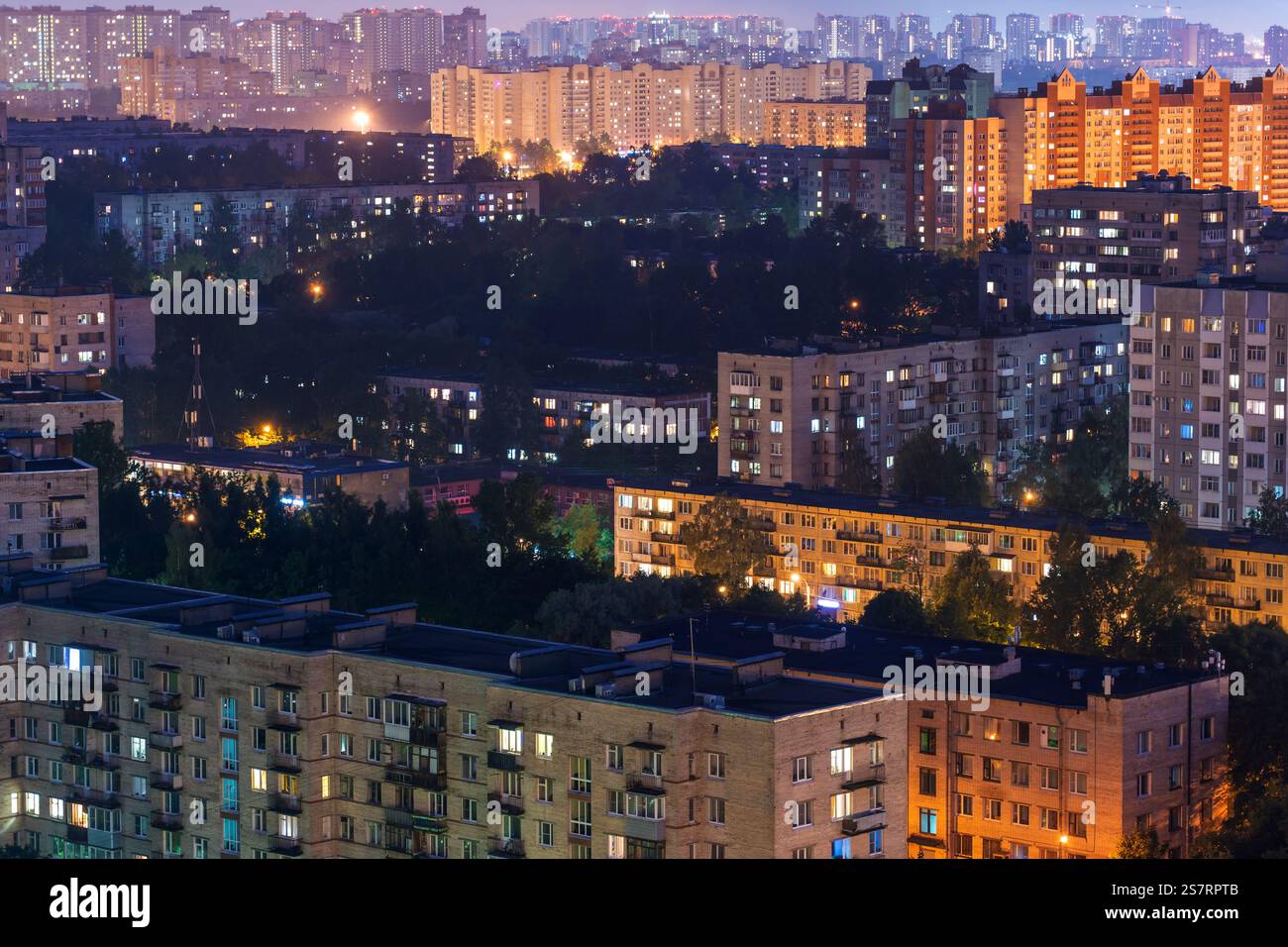 High rise residential buildings illuminating the night sky in a densely ...