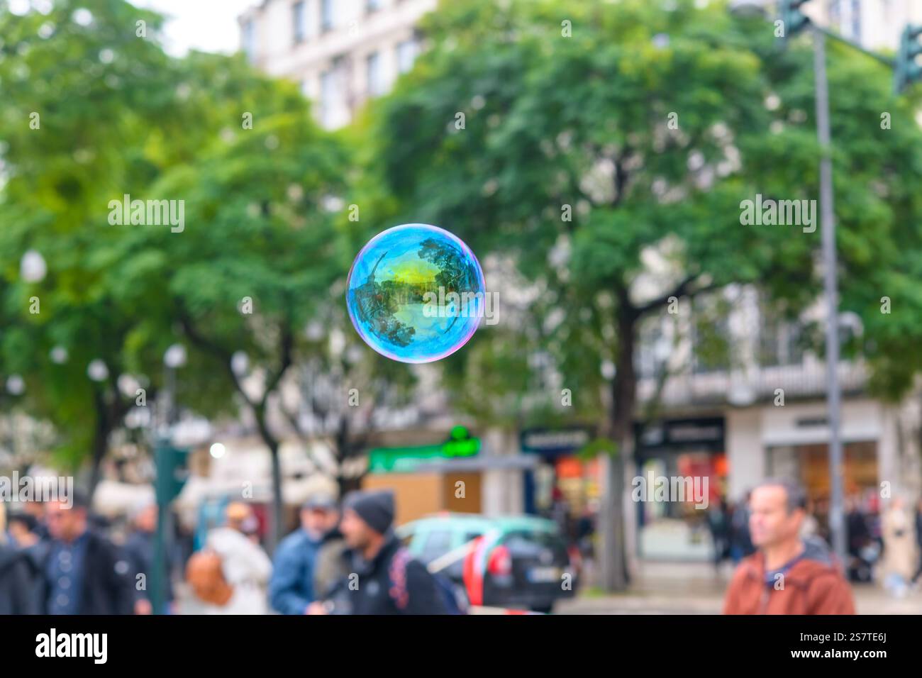 A soap bubble floats in a town square during a protest against the Islamic Republic of Iran, created by someone not associated with the protest. Stock Photo