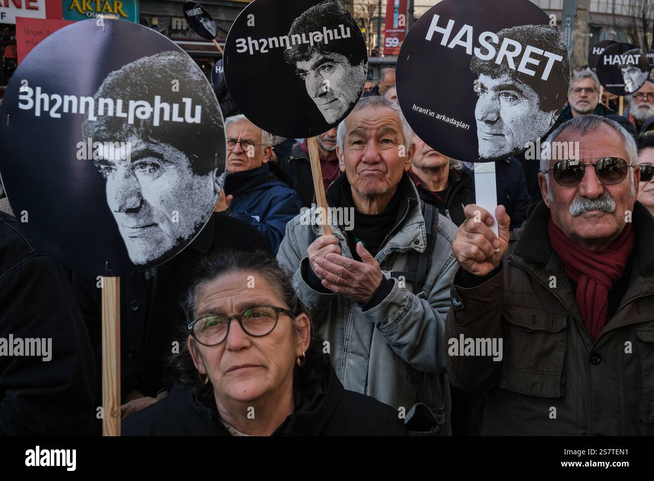 those-attending-the-commemoration-carry-a-placard-featuring-photographs