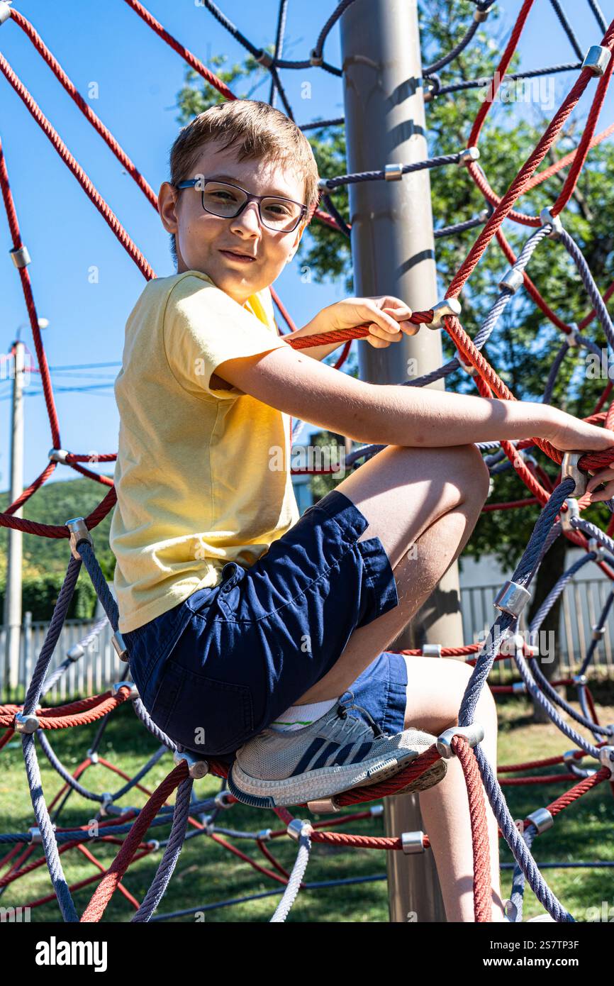 Teenager boy playing on the rope playground Stock Photo - Alamy