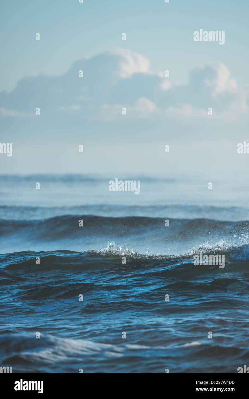 Ocean Waves Crashing Under a Blue Sky with Puffy Clouds Stock Photo - Alamy