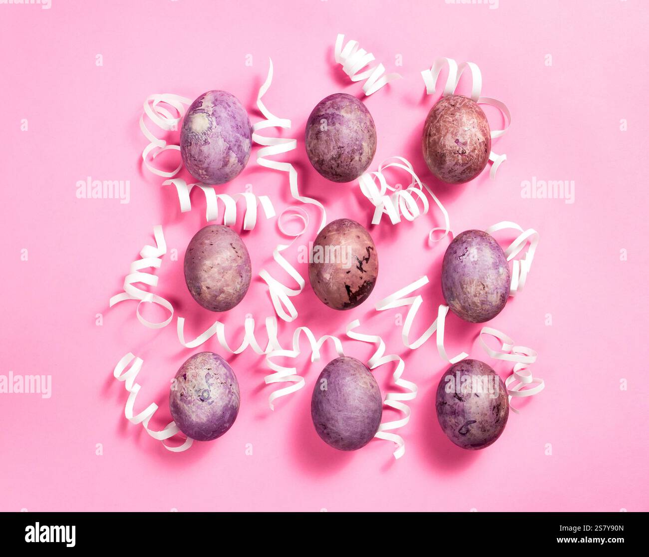 Easter eggs with white decorations on pink background. Easter layout. Greeting card design Stock Photo