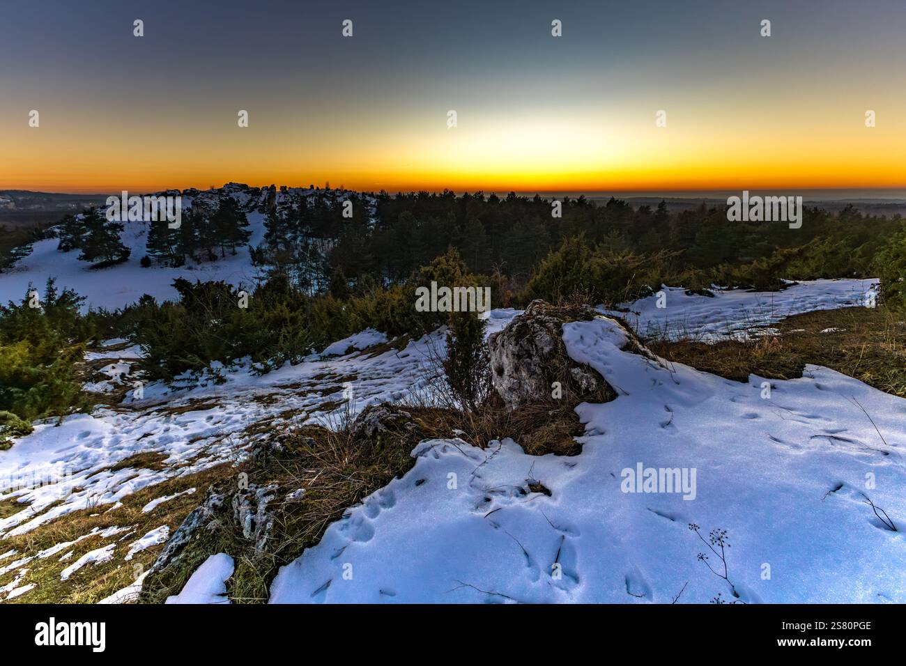 Sunset in winter over the mountain peaks, Krakow-Czestochowa Jura, Towarne Mountains, play of colors in the sky Poland Stock Photo