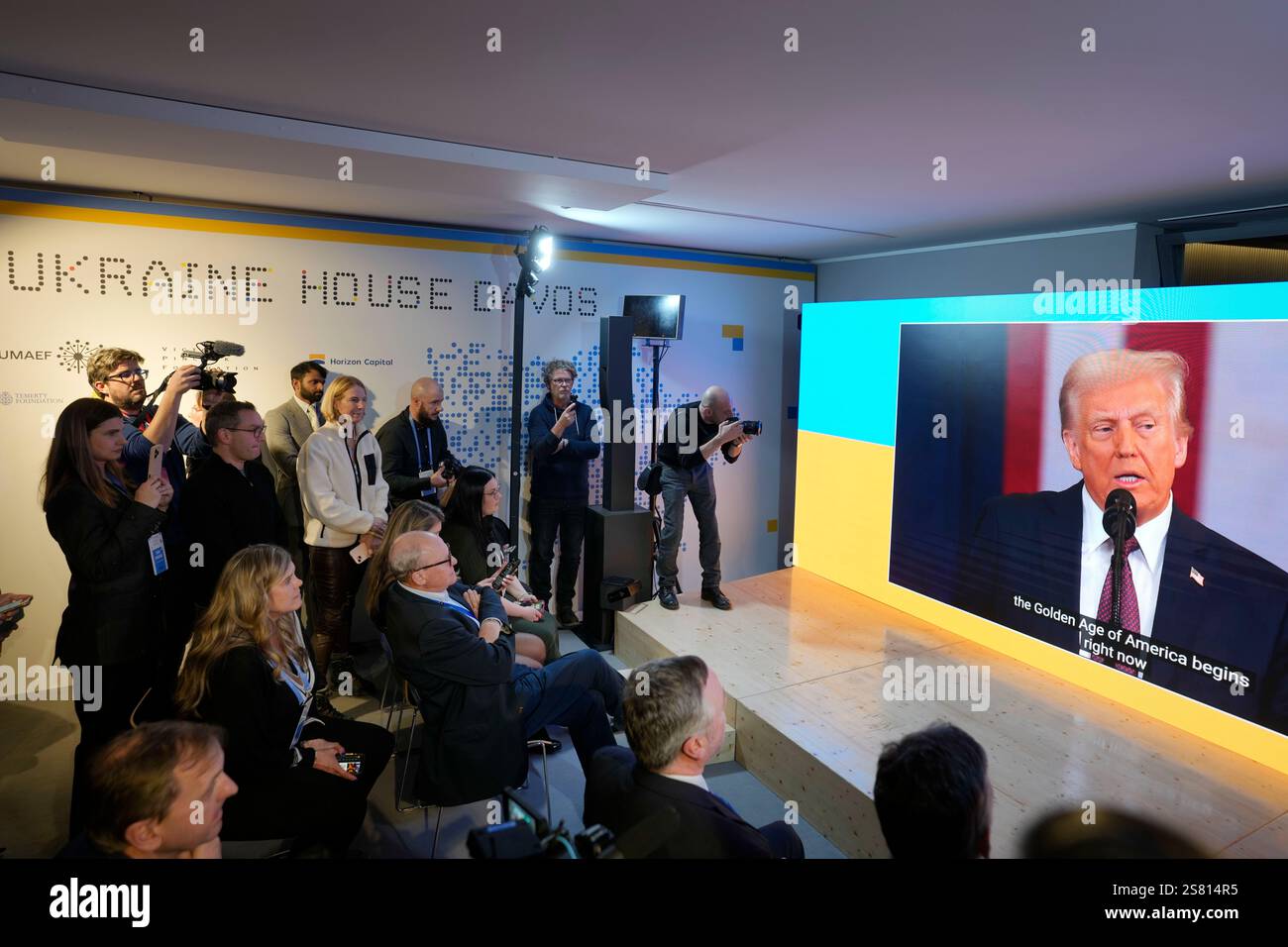 People watch the inauguration speech of Donald Trump on screens at the