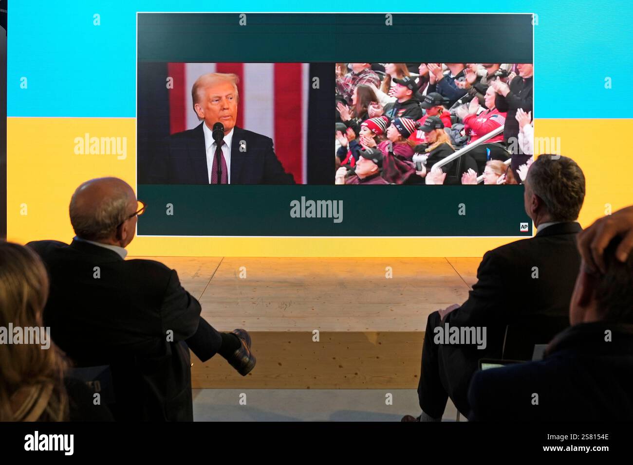 People watch the inauguration speech of Donald Trump on screens at the