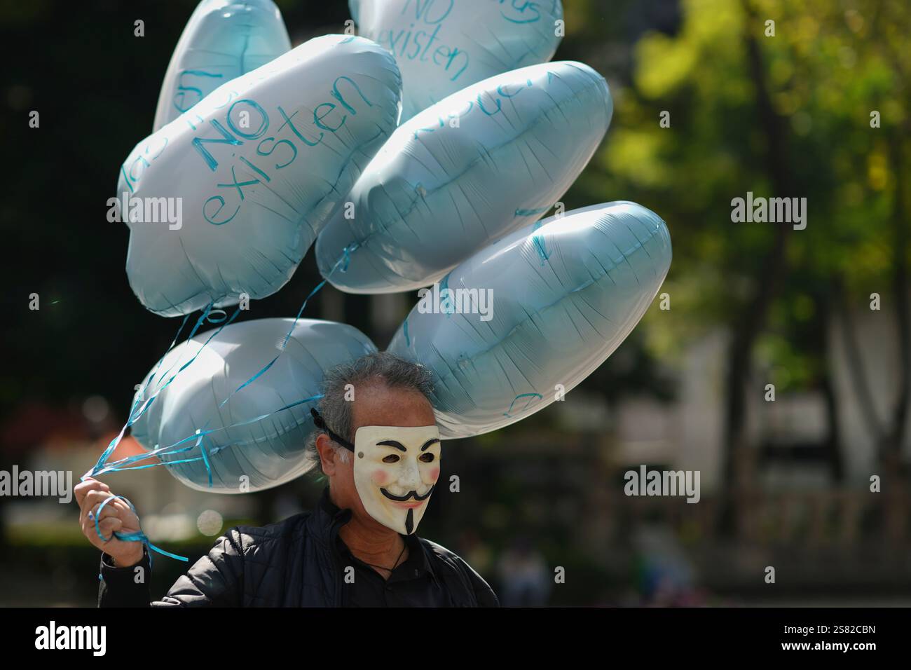 A protester with balloons that say in Spanish "Borders don't exist