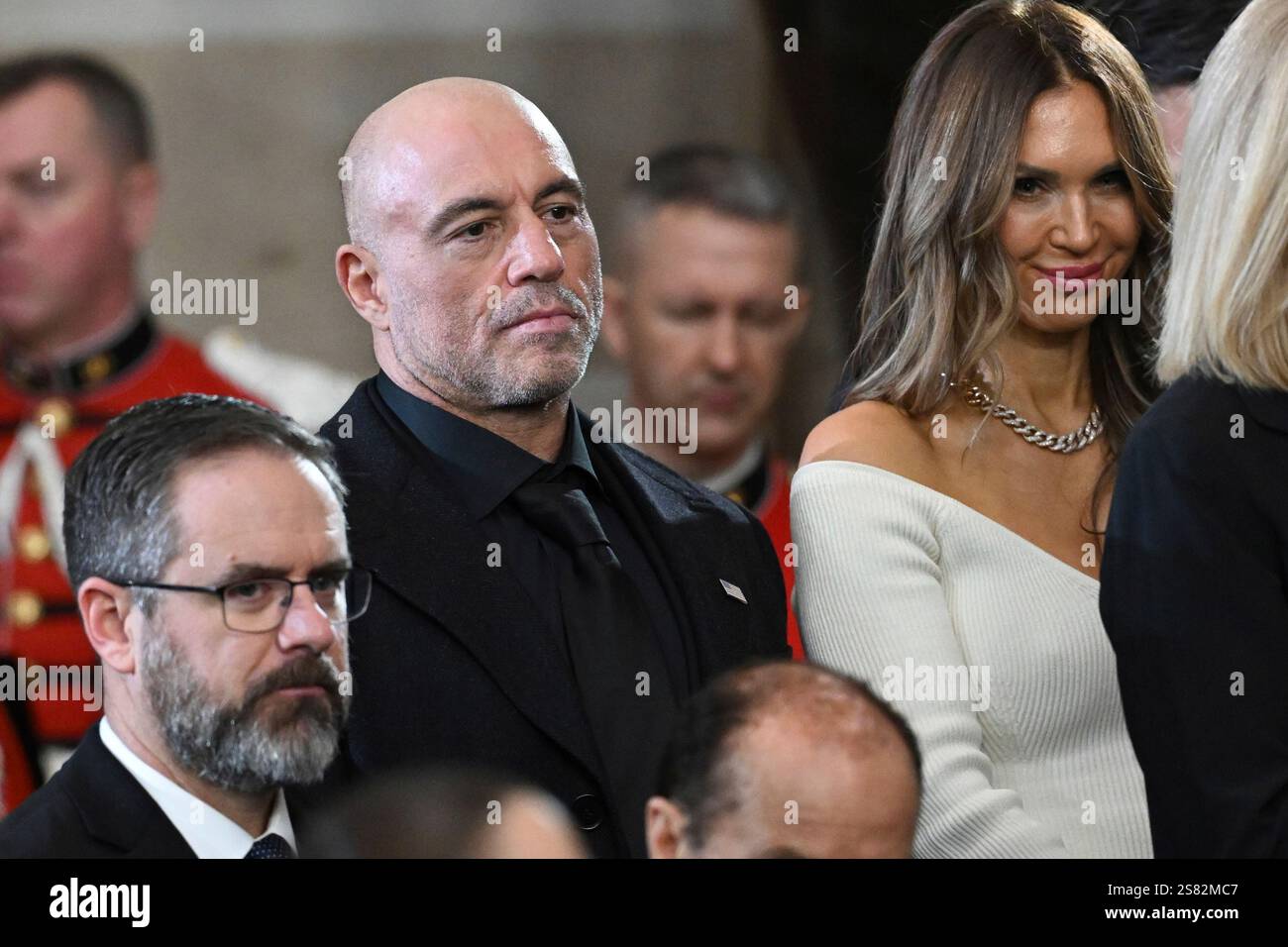 Joe Rogan stands for a benediction after President Donald Trump was sworn in during the 60th