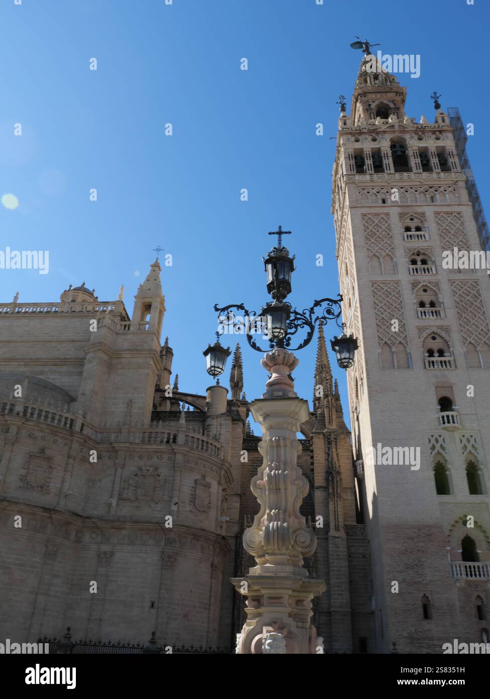 Lamppost with many lamps from the Fuente de la Farola in front of the La Giralda bell tower in the Plaza de la Virgen de los Reyes in Seville Spain Stock Photo