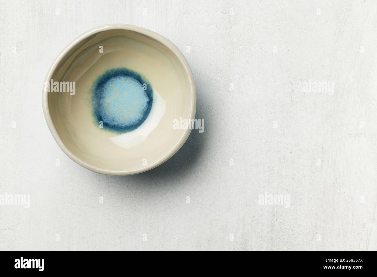 empty ceramic bowl on white painted table surface, top view Stock Photo