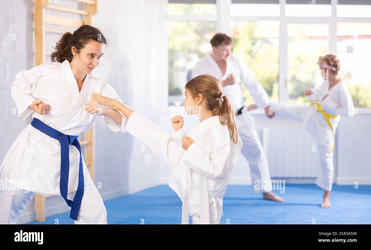 Preteen Girl In Kimono Practicing Karate Kicks During Sparring With preteen-girl-in-kimono-practicing-karate-kicks-during-sparring-with
